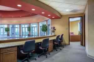 een kantoor met een lange bar met stoelen ervoor bij Embassy Suites Loveland Conference Center in Loveland