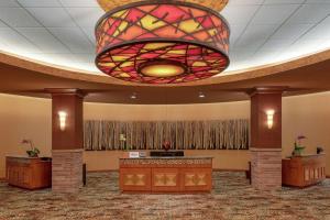 een grote lobby met een grote glas-in-loodkroonluchter bij Embassy Suites Loveland Conference Center in Loveland