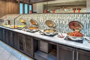 una linea a buffet con molti piatti di Embassy Suites by Hilton Indianapolis North a Indianapolis