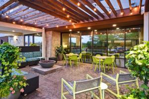 an outdoor patio with tables and chairs and windows at Home2 Suites By Hilton Frankfort in Frankfort