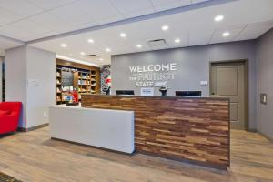 a welcome brightfoot store with a red chair in a lobby at Hampton Inn Cape Cod Canal in Buzzards Bay