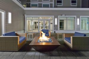 a patio with two chairs and a fire pit at Hampton Inn Cape Cod Canal in Buzzards Bay