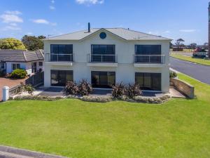 uma casa branca com um jardim verde em Clifftop Apartments Portland Vic em Portland