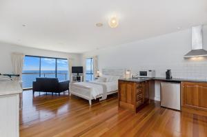 uma cozinha e sala de estar com uma cama e um sofá em Clifftop Apartments Portland Vic em Portland