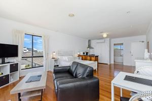 uma grande sala de estar com um sofá e uma cama em Clifftop Apartments Portland Vic em Portland