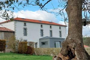 un grande edificio bianco con tetto rosso di LE FIEF GUIBERT Hôtel particulier Maison d'hôtes et Gîtes a Le Poiré-sur-Vie