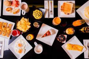 - une table avec des assiettes de produits pour le petit-déjeuner et des boissons dans l'établissement HF Fenix Music, à Lisbonne