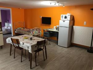 uma cozinha com uma mesa e um frigorífico branco em Gîte cosy à Ville-au-Val, proche Nancy et Metz, randonnées, 1 chambre, parking et terrain privé. - FR-1-584-111 em Ville-au-Val