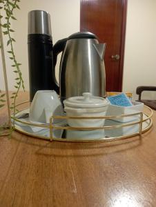 a tray with a coffee pot and dishes on a table at casa SKALA in Puno