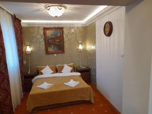 a bedroom with a bed with two towels on it at Pensiunea Crown Royal in Alba Iulia