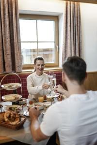 a man and a woman sitting at a table at Wellness-Appartements Berchtesgadener Land in Ainring