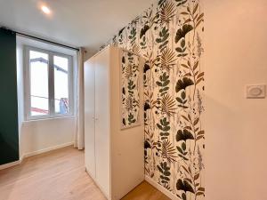 Cette chambre est dotée d'un mur avec un papier peint à fleurs. dans l'établissement LA FEUILLERAIE N2-Standingappart-Wifi-Proche ville, à Fontenay-le-Comte