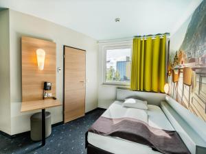 Un pat sau paturi într-o cameră la B&B Hotel Weil am Rhein/Basel