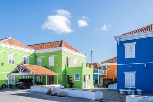 une rangée de maisons colorées dans un parking dans l'établissement The Freedom Hotel, à Willemstad