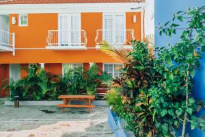 Un bâtiment orange avec une table de pique-nique devant. dans l'établissement The Freedom Hotel, à Willemstad