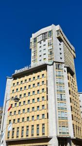 um edifício alto com uma placa no topo em Barceló Ourense em Ourense