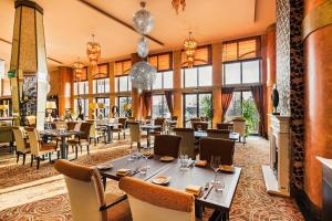 un restaurant avec des tables, des chaises et des fenêtres dans l'établissement Hotel Savannah, à Chvalovice