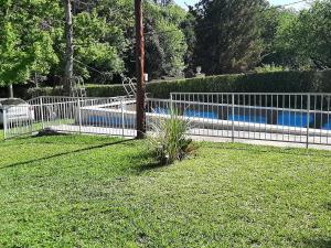 une clôture dans une cour avec une piscine dans l'établissement Sierras Chicas La Granja, à Córdoba