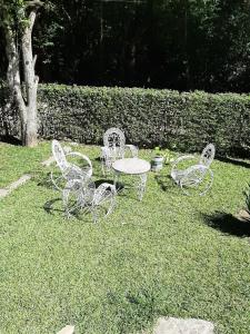 un groupe de chaises blanches et d'une table dans l'herbe dans l'établissement Sierras Chicas La Granja, à Córdoba