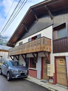 ein Auto, das vor einem Haus mit Balkon parkt in der Unterkunft Appartement Le Clos Fleuri 1 in Sixt