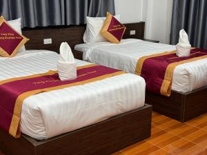 - 2 lits dans une chambre d'hôtel avec des serviettes dans l'établissement VangVieng Charming Boutique Hotel, à Vang Vieng