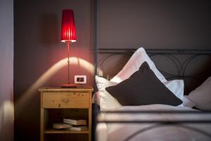 a red lamp on a night stand next to a bed at Hotel Acadia - Adults Mountain Home in Selva di Val Gardena