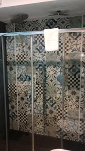 a bathroom with a shower and a wall with tiles at locanda genovese 20 in La Maddalena