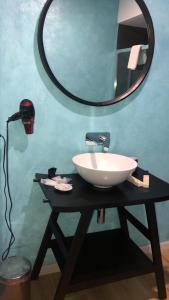 a bathroom with a sink and a mirror on a table at locanda genovese 20 in La Maddalena