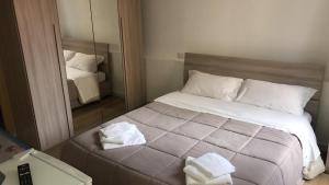 a bedroom with a large bed and a mirror at locanda genovese 20 in La Maddalena