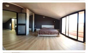 a large bedroom with a bed and large windows at locanda genovese 20 in La Maddalena