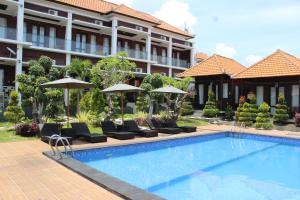 un hotel con piscina con sedie e ombrelloni di Nusa Sedayu Hotel By Ocean View a Nusa Penida