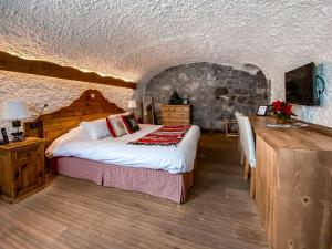 a bedroom with a bed in a room with a stone wall at Les Chalets de la Serraz in La Clusaz