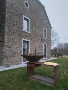 una parrilla de piedra frente a un edificio de ladrillo en Gîte Le Framboisier V de la distillerie Bio Spirit Belgium, en Neufchâteau