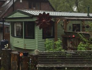 une maison verte avec une fleur à l'avant dans l'établissement Secluded Woodland Hideaway - 2 Bed with Private Parking, à Emsworth