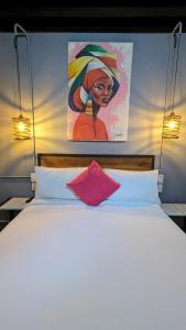 een slaapkamer met een bed met een schilderij aan de muur bij Maloka Boutique Hostel in Cartagena