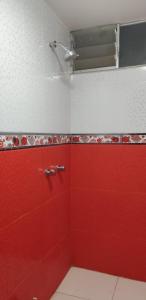 a bathroom with red and white tiles and a red wall at PEPE´S HOUSE in Puno