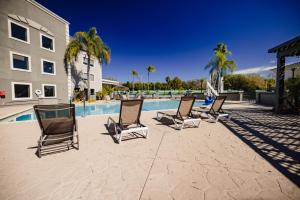 um grupo de cadeiras sentadas ao lado de uma piscina em La Quinta Inn by Wyndham Tampa Near Busch Gardens em Tampa