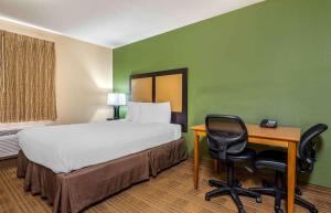 um quarto com uma cama, uma secretária, uma cama e uma cadeira em Extended Stay America Suites - Evansville - East em Evansville