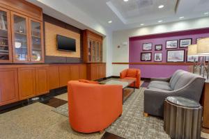 una sala d'attesa con sedie arancioni e TV di Drury Inn & Suites Baton Rouge a Baton Rouge