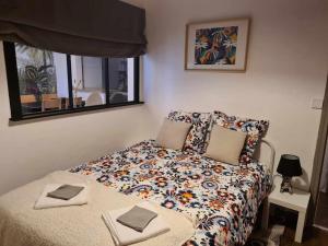 1 dormitorio con 1 cama con edredón de flores en L’Oasis Fleuri, en Bourg-de-Péage