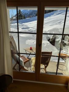 een uitzicht vanuit een raam van een kamer met een tafel bij Chalet Studio - Top Ausstattung - beste Lage Davos in Davos