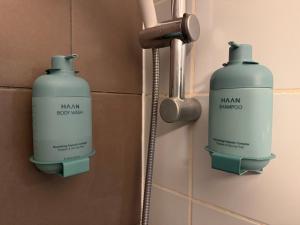 2 botellas de champú en la pared del baño en Le 2 by Hotel Akena - Nantes Beaujoire, Porte de Sainte Luce, en Sainte-Luce-sur-Loire