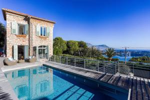 a villa with a swimming pool in front of a house at Villa Élégante Nice avec Vue Mer in Nice