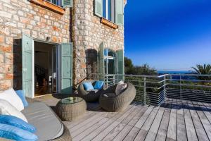 a patio with two chairs and a couch on a deck at Villa Élégante Nice avec Vue Mer in Nice