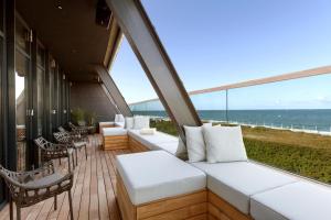 einen Balkon mit weißen Möbeln und Meerblick in der Unterkunft Wyn. Strandhotel Sylt in Westerland