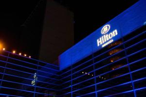 Hilton Mendoza في ميندوزا: مبنى ذو إضاءة زرقاء مع علامة هيلتون