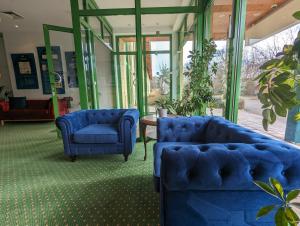 twee blauwe stoelen en een tafel in een kamer bij Acron-Hotel Quedlinburg in Quedlinburg