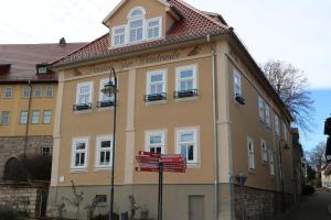 ein gelbes Gebäude mit einem Schild davor in der Unterkunft Gasthaus Zur Weintraube in Bad Langensalza