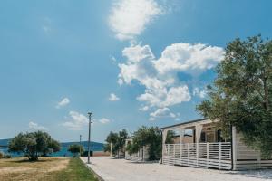 um edifício na praia com um céu azul e nuvens em San Antonio mobile homes em Biograd na Moru