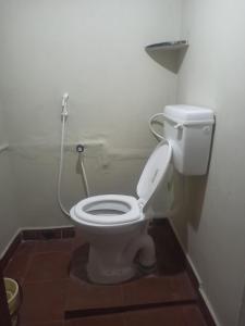 ein Badezimmer mit einem weißen WC mit einem Schlauch in der Unterkunft Uthamar Illam in Tiruchchirāppalli